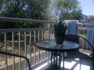 a table and chairs on a balcony with a potted plant at My Lemnos Studios - Studio 2 in Repanídhion