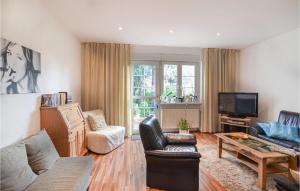 ein Wohnzimmer mit einem Sofa und einem TV in der Unterkunft Ferienhaus Altenescher Weg J in Berlin