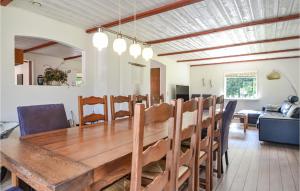 een eetkamer en een woonkamer met een houten tafel en stoelen bij Cozy Home In Varde With Wifi in Varde