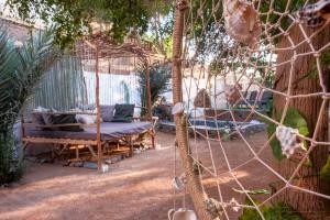 uma cama de baloiço num jardim com uma cerca em Villa Can Kiko em Dahab