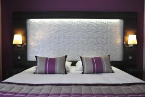 - une chambre avec un grand lit et 2 oreillers dans l'établissement The Originals Boutique, Hôtel Le Lion d'Or, Fougères Ouest (Inter-Hotel), à Saint-Brice-en-Coglès