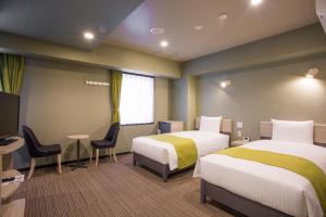 a hotel room with two beds and a tv at Kuretake Inn Nagoya Hisayaodori in Nagoya +37 photos