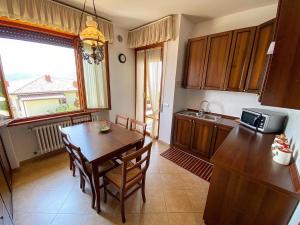 a kitchen with a wooden table and a dining room at Villa Belvedere Liberty in Costermano
