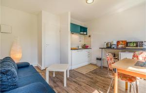 a living room with a blue couch and a table at Stunning Apartment In St Annen in Sankt Annen +9 photos