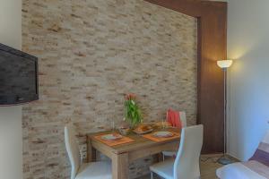 ein Esszimmer mit einem Holztisch und weißen Stühlen in der Unterkunft Renas Cosy Apartment in Korfu-Stadt