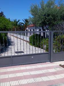 a black gate with a sidewalk and a tree at Cassa Jessi in Tarragona