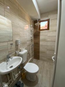 a bathroom with a white toilet and a sink at Motel Atika in Skopje