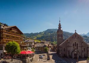 una pequeña ciudad con una iglesia y una torre del reloj en Studio Forclaz, en Le Grand-Bornand