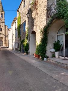 una calle vacía con plantas al lado de un edificio en Sinti, en Saint-Hilaire-dʼOzilhan