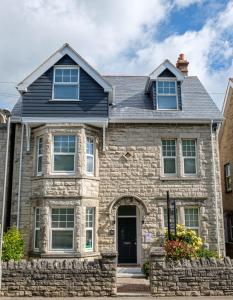 una casa de piedra con techo azul en Millbrook Guest House, en Swanage