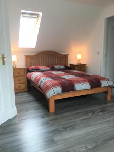 a bedroom with a bed and two night stands and a window at Kilberry Guest House in Beauly