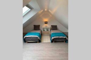 a attic bedroom with two beds and a window at Appartement 3km Disneyland Paris 4 à 6 personnes in Magny-le-Hongre
