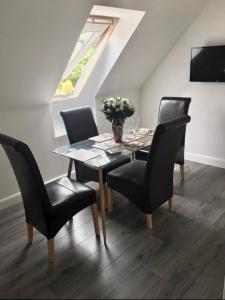 een eettafel met stoelen en een vaas met bloemen bij Kilberry Guest House in Beauly