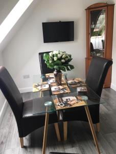 a dining room table with black chairs and a vase of flowers at Kilberry Guest House in Beauly