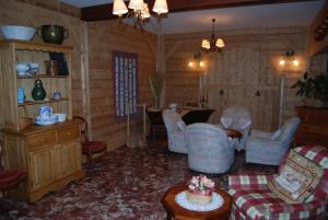 a living room with chairs and a cake on a table at Hôtel De La Couronne in Mijoux