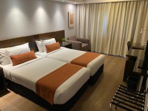 a hotel room with a large bed and a chair at Crystal Tower in Montevideo