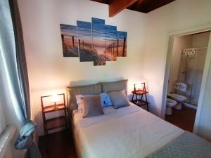 una camera da letto con un letto con due lampade e due quadri alle pareti di Casa das Laranjeiras e parque infantil a Villa Nogueira Altre 30 foto
