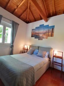 um quarto com uma cama num quarto com 2 candeeiros em Casa das Laranjeiras e parque infantil em Villa Nogueira