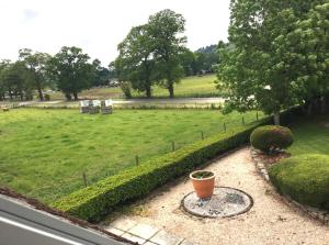 a window view of a park with a flower pot at Kilberry Guest House in Beauly