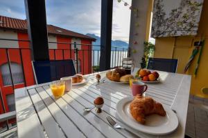 einen Tisch mit 2 Tellern Essen auf einem Balkon in der Unterkunft Wohnung mit Seeblick, Strandnähe und Tiefgaragen Stellplatz in Acquaseria