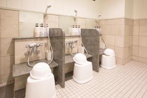 a public bathroom with three sinks and toilets at Kuretake Inn Nagoya Hisayaodori in Nagoya