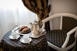 une bouilloire et un plateau de beignets sur une table dans l'établissement Hotel Fontebella, à Assise