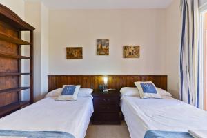 a bedroom with two beds and a dresser at Apartamento Yaiza in Nerja +32 photos