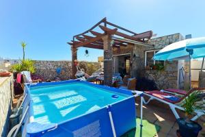 a swimming pool in a backyard with a wooden pergola at Apartamento Yaiza in Nerja
