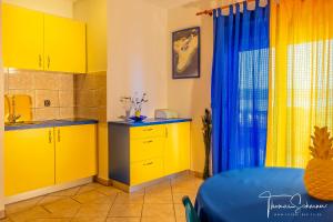 una cocina con armarios amarillos y una mesa azul en Apartments Natali, en Sveti Petar