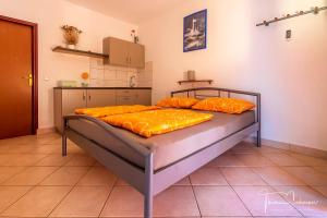 1 dormitorio con 2 camas con almohadas de color naranja en Apartments Natali, en Sveti Petar