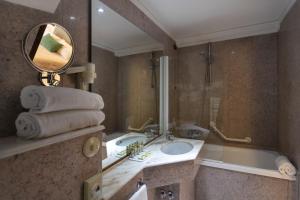 a bathroom with a sink and a tub and a mirror at Hotel Fontebella in Assisi