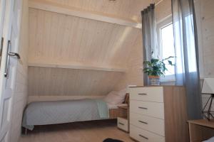 a small bedroom with a bed and a window at Domki Perłowe in Dąbki +30 photos