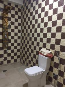 een badkamer met een toilet en een geruite muur bij VILLA RYAD SAIDIA in Saidia 
