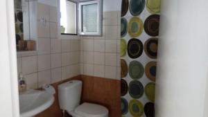 uma casa de banho com um WC, um lavatório e uma janela em John Galouzis Studios em Kalymnos