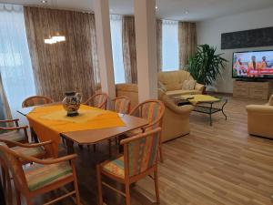 a living room with a table and chairs and a television at Zirbe - Bayerischer Hof in Rüdesheim am Rhein