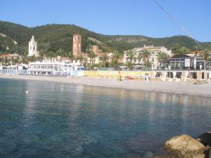 una spiaggia con un gruppo di edifici e l'acqua di Casa x vacanze in centro a Noli 009042-LT-0267 a Noli