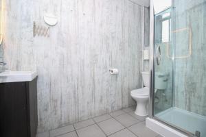 a bathroom with a toilet and a glass shower at City Apartments in Glasgow