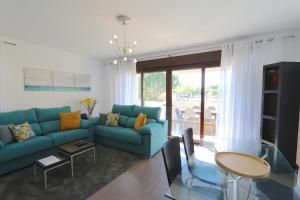 uma sala de estar com um sofá azul e uma mesa em Monte Laguna - Clever Details em Vilamoura