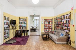 a living room with a couch and some books at Baroque Hostel & Coworking in Budapest