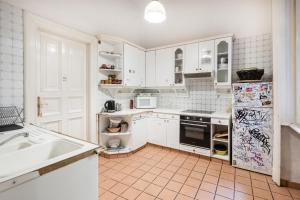 a kitchen with white cabinets and white appliances at Baroque Hostel & Coworking in Budapest