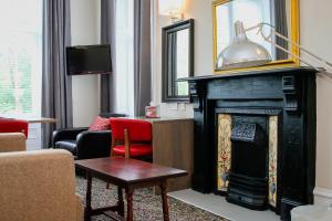 a living room with a fireplace and a red chair at City Apartments in Glasgow