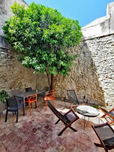 a patio with chairs and a table and a tree at L ORANGER - Plein centre - 6 Personnes - Clim in Cassis