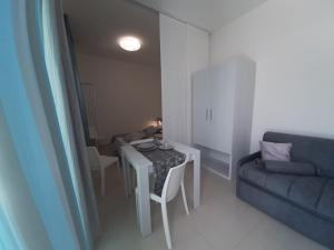 un piccolo soggiorno con tavolo e divano di GIOANTHONY monolocale a Porto Cesareo Altre 9 foto