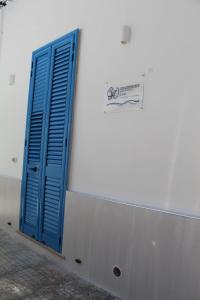 una porta blu sul lato di un edificio bianco di GIOANTHONY monolocale a Porto Cesareo