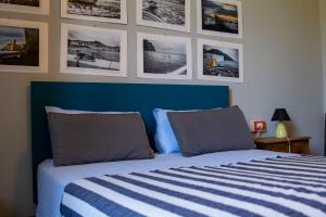 a bedroom with a blue and white bed with pictures on the wall at L'Andirivieni in Camogli
