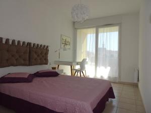 a bedroom with a bed and a table and a window at Les Manades in Aigues-Mortes