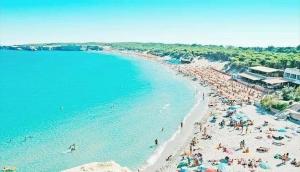 a beach with a lot of people and the ocean at Villetta Carati in Torre dell'Orso