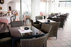 a dining room with tables and chairs and tablesktop at HOTEL GIAMAICA in Cattolica