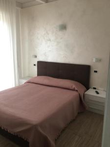 a bedroom with a large bed with a pink blanket at HOTEL GIAMAICA in Cattolica