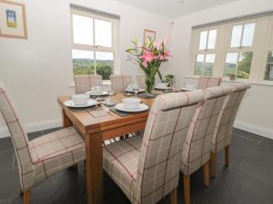 a dining room table with chairs and a vase of flowers at Dereside in Hexham